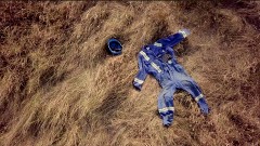 A blue construction outfit laying in a field