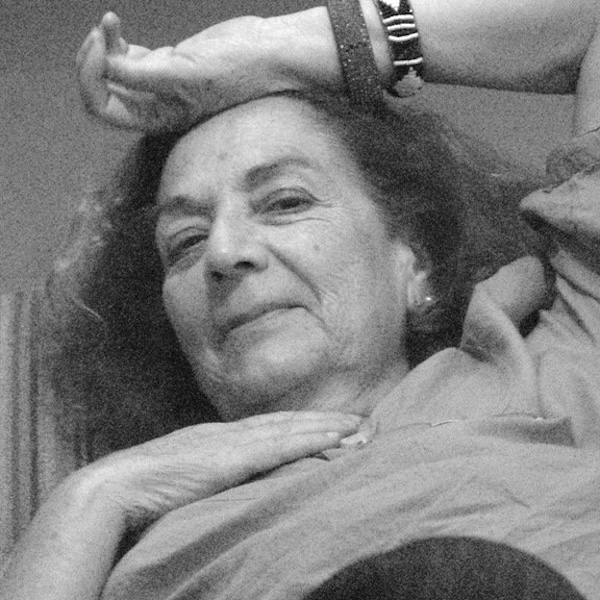 Black and white photography closeup of an older woman reclined and staring at the viewer.