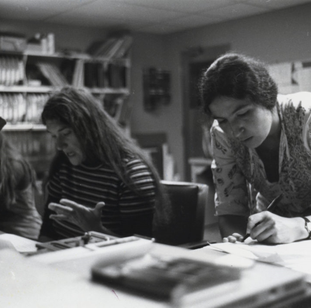 Black and white photo of two woment working together in an office. 