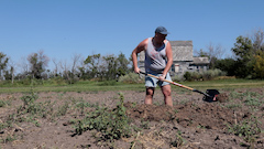 Image of the artist digging in a prairie field