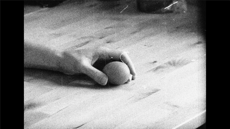 Image fixe en noir et blanc d'une main tenant un œuf.
