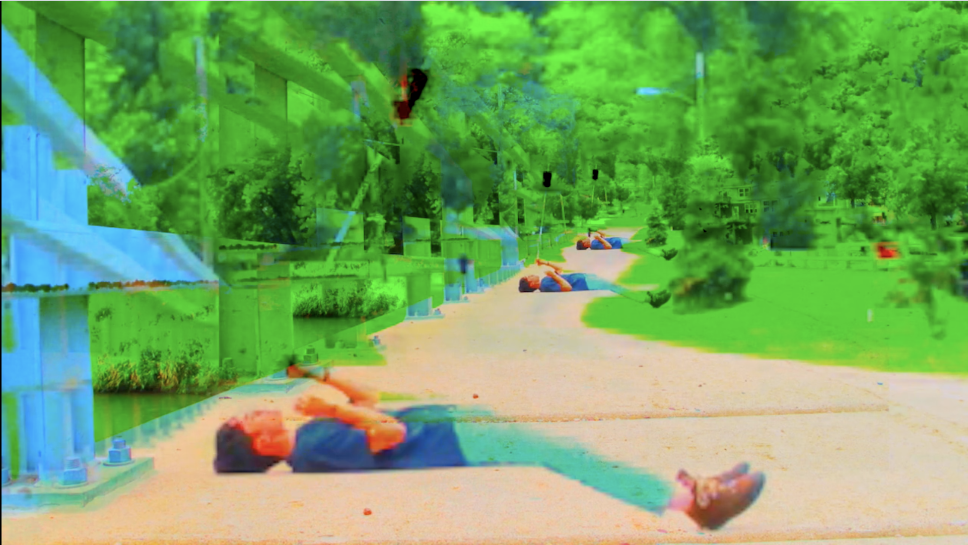 Saturated image with digital glitches of a person laying on the ground holding a stick in the air