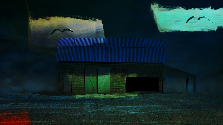 Image couleur sombre et maussade d'une vieille grange et de corbeaux volant dans le ciel nocturne.