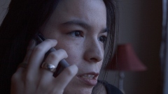 A close up shot of a woman's face as she speaks on a cellphone.