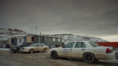 Des automobiles stationné à côté de maisons mobiles à Iqaluit 