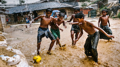 Des jeunes Rohingyas joue le soccer dans la pluie 