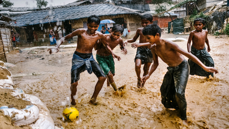 Des jeunes Rohingyas joue le soccer dans la pluie 