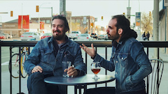 Deux hommes, portant des veste en jean, se parle sur une terrace