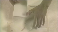 Colour image closeup of a pair of hands holding files from a manila file folder.
