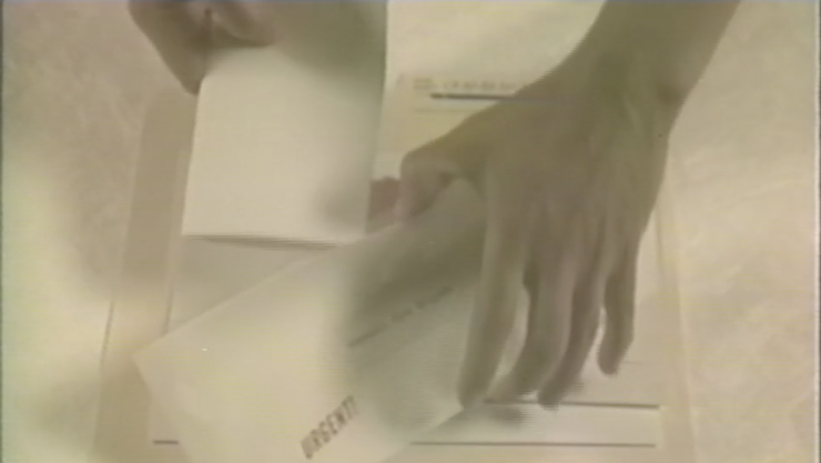 Colour image closeup of a pair of hands holding files from a manila file folder.