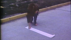 Vintage colour grainy image of a person with long hair kneeling down and a hand on a paper scroll.