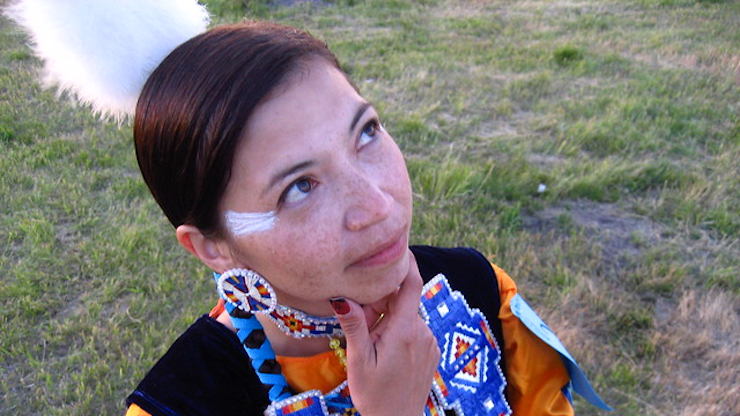 A closeup of an indigenous woman dressed in a colourful traditional costume, seen from above.