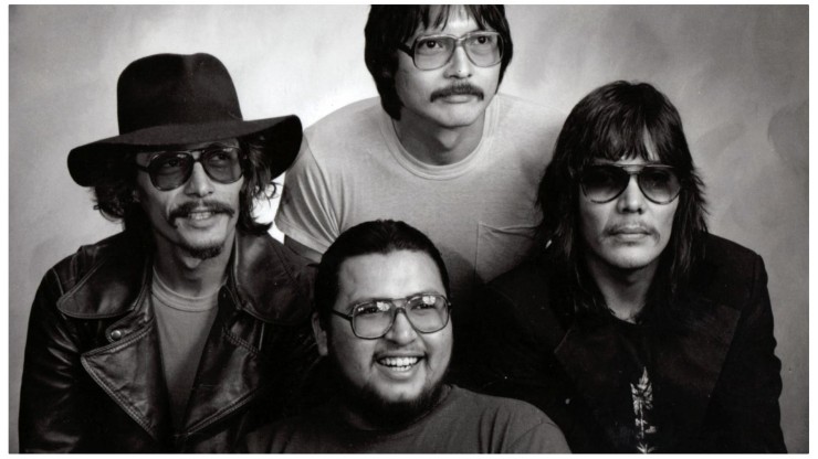 four Indigenous men in a black and white photo, some our smiling some have a straight face